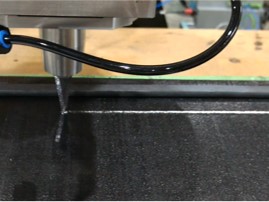 The ultrasonic trimming knife cutting a composite stack.