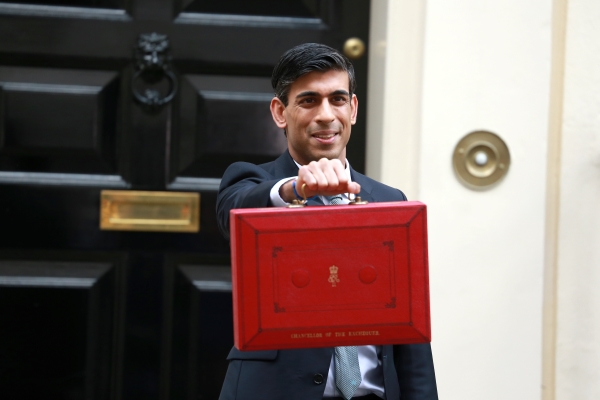 Rishi holding the budget red suitcase